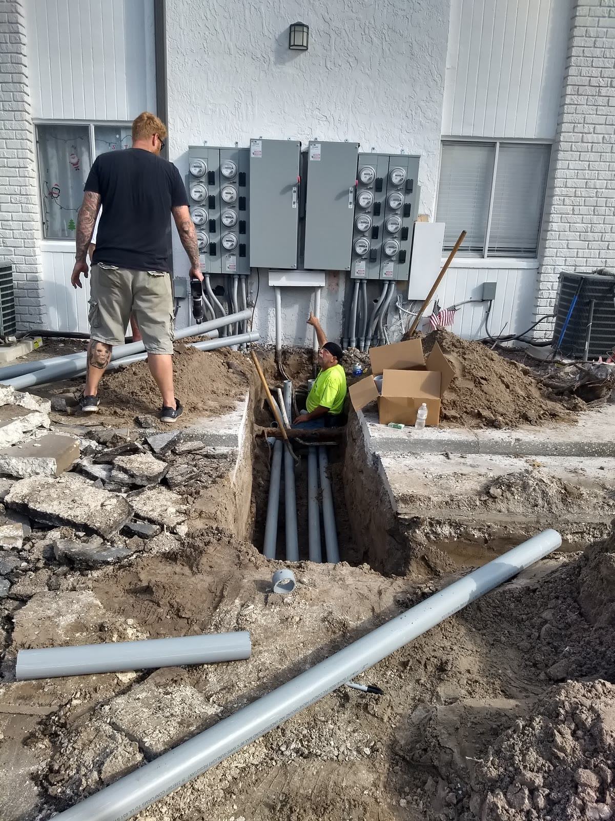 Brightwire Electric electricians running underground conduit to a commercial meter bank