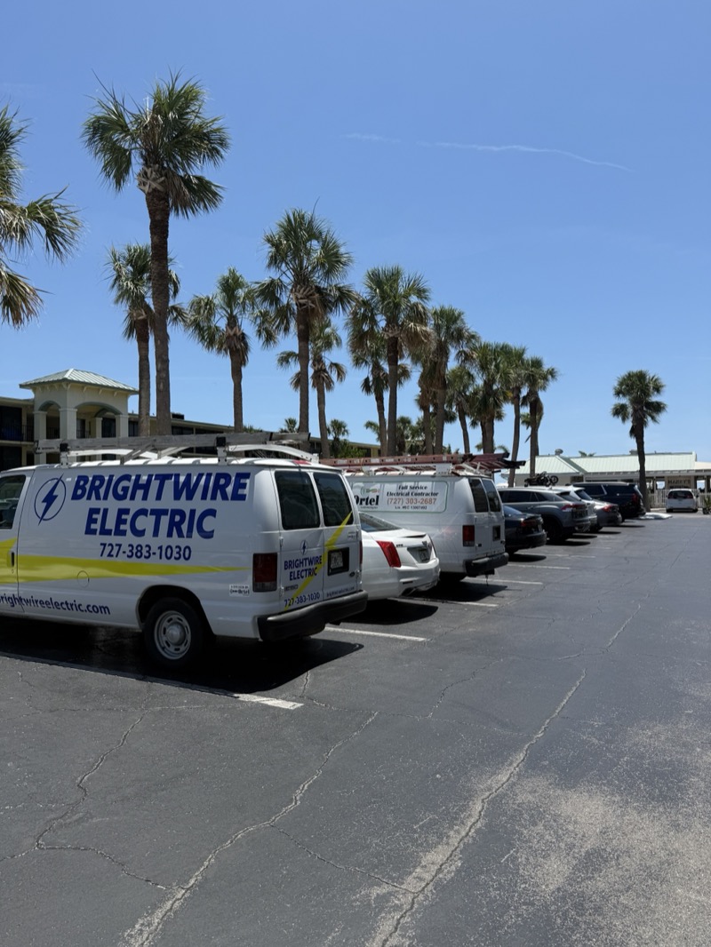 Brightwire Electric branded vans parked in lot with palm trees in Tampa Bay Florida